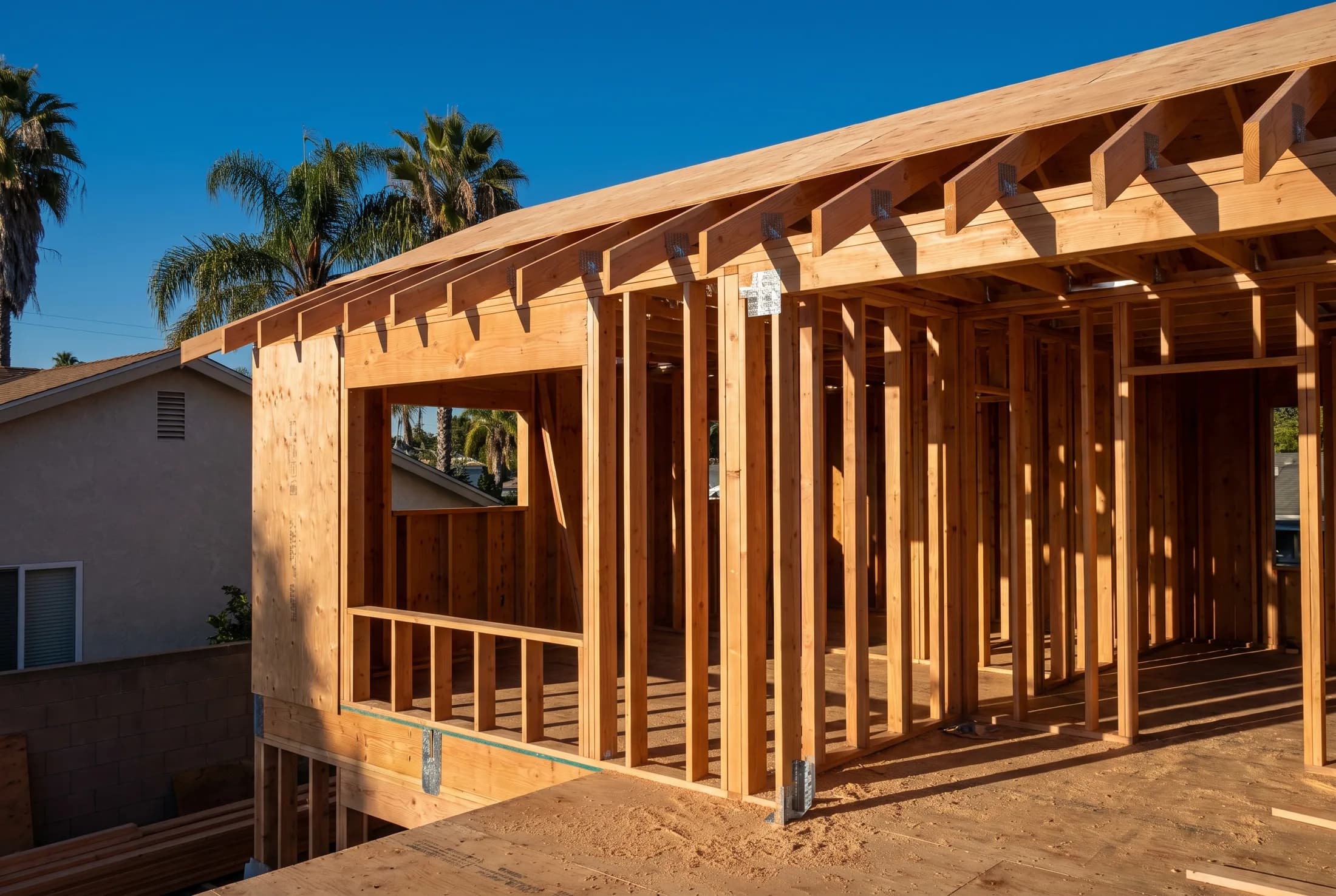 New Douglas fir framing and rafters standing open against a clear San Diego sky