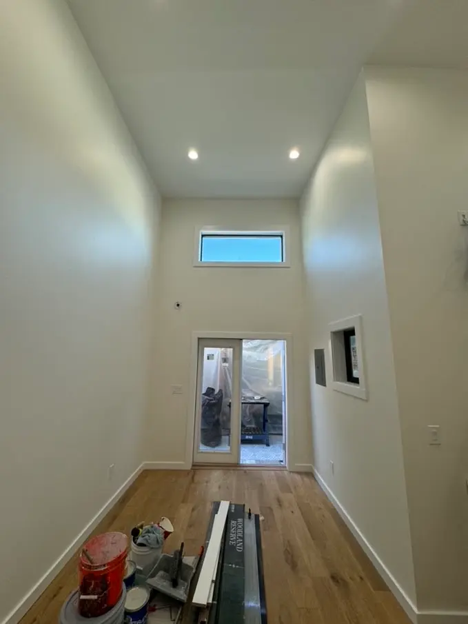 Finished garage conversion interior with high ceilings, recessed lighting, and wood flooring in San Diego